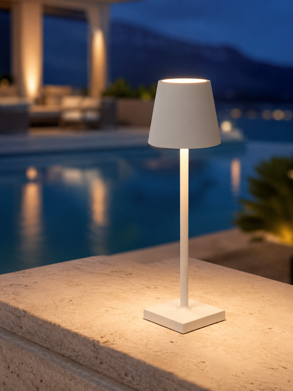 Marin white cordless lamp on a travertine ledge at dusk